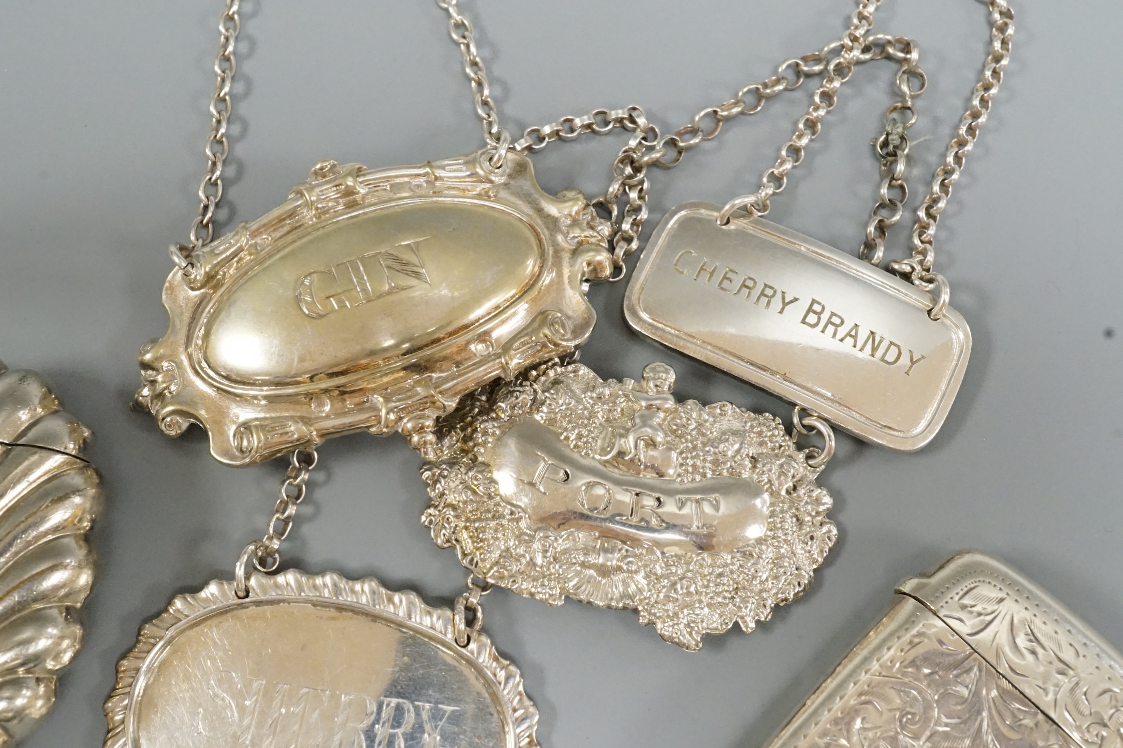 Two silver wine labels including 19th century, silver vesta case, silver cheroot holder, silver lyre menu holder and other items.